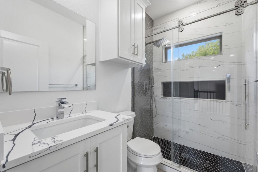 One of two second-floor bathrooms, this one offers plenty of storage, a convenient walk-in shower with a large soap niche, and natural light pouring in through the window. One of two second-floor bathrooms, this one offers plenty of storage, a convenient walk-in shower with a large soap niche, and natural light pouring in through the window.