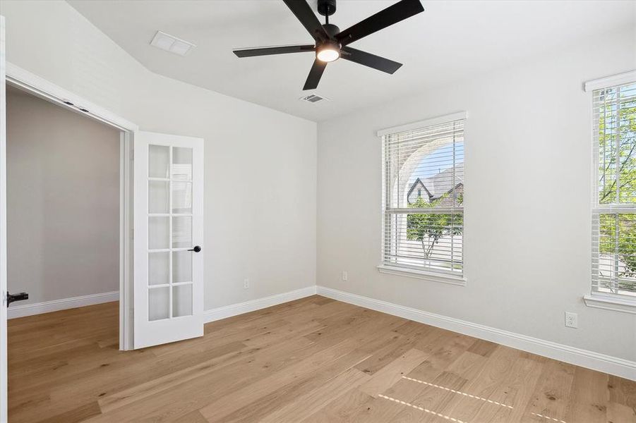 Unfurnished room featuring light wood-type flooring, baseboards, and a ceiling fan