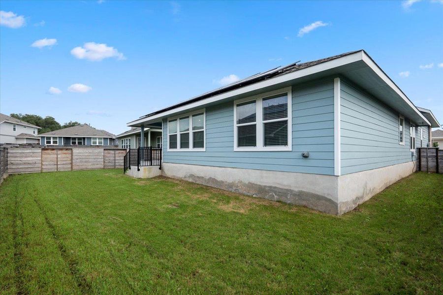 A fenced backyard offers a private outdoor space for leisure and recreation, complemented by the modern siding of the home. A fenced backyard offers a private outdoor space for leisure and recreation, complemented by the modern siding of the home.
