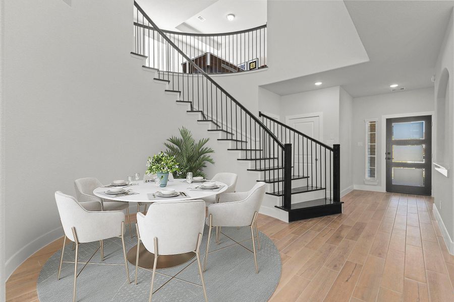 Casual dining area with two story high ceilings highlights the open concept and natural flow between living spaces. Light wood-look tile flooring and soaring ceilings enhance the home’s modern yet welcoming ambiance. *Photo Staged*