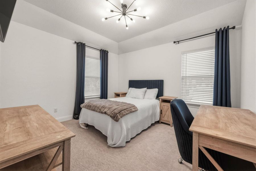 Bedroom featuring a walk-in closet and two windows with blinds