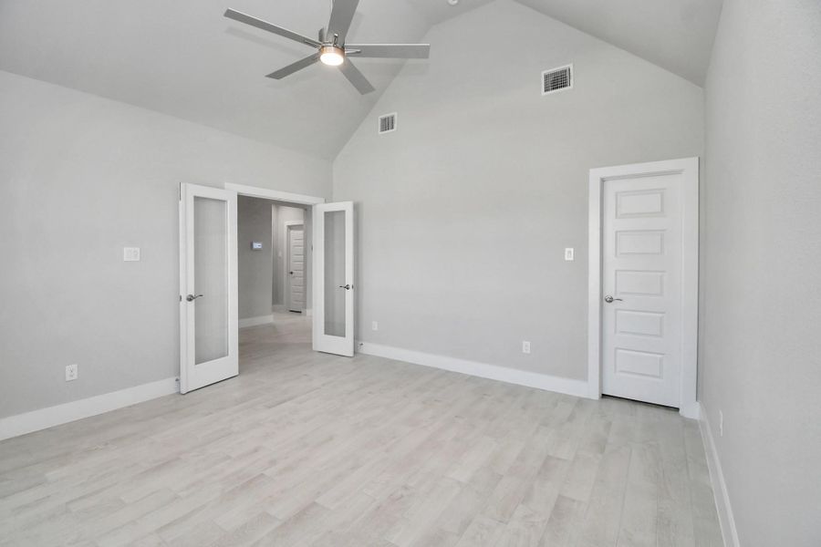 Experience the perfect blend of sophistication and warmth in this home office, boasting elegant wood-look tile flooring and flooded with natural light from expansive windows and French doors. Sample photo of completed home with similar floor plan. Actual colors and selections may vary.