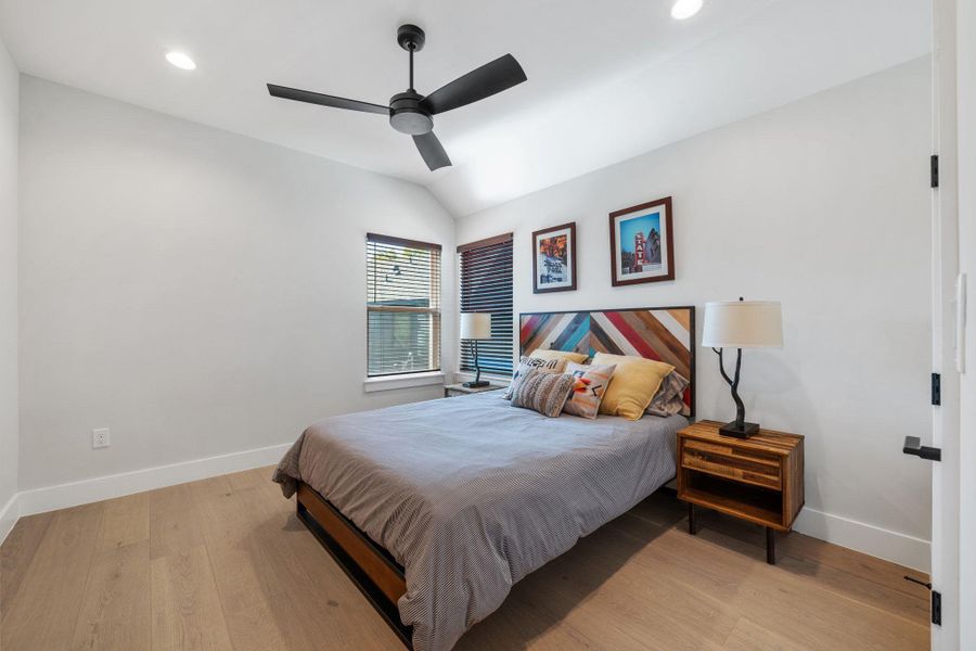 Bedroom with light wood finished floors, lofted ceiling, a ceiling fan, and recessed lighting
