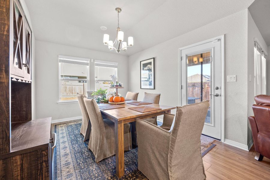 Dining space featuring light wood finished floors and a chandelier Dining space featuring light wood finished floors and a chandelier