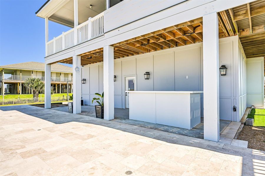 The lower outdoor entertaining area offers space for grilling, dining, and gathering after long beach days. Designed with Golf Cart and RV garage access, it extends the luxury lifestyle outdoors.