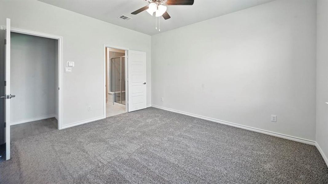 Unfurnished bedroom with carpet flooring, ceiling fan, and ensuite bathroom Unfurnished bedroom with carpet flooring, ceiling fan, and ensuite bathroom