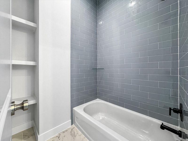The tub/shower enclosure with built in cabinetry.