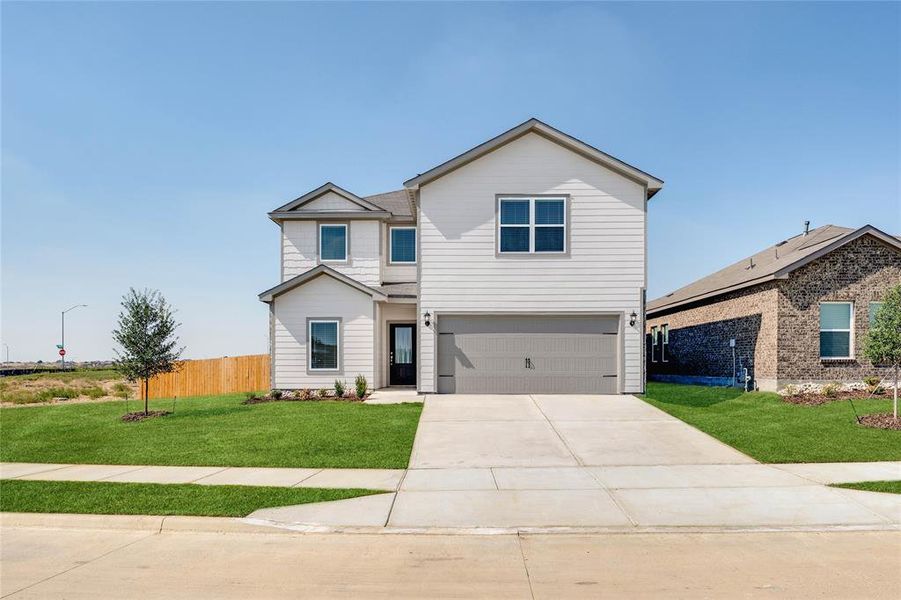 View of front of home featuring concrete driveway and an attached garage