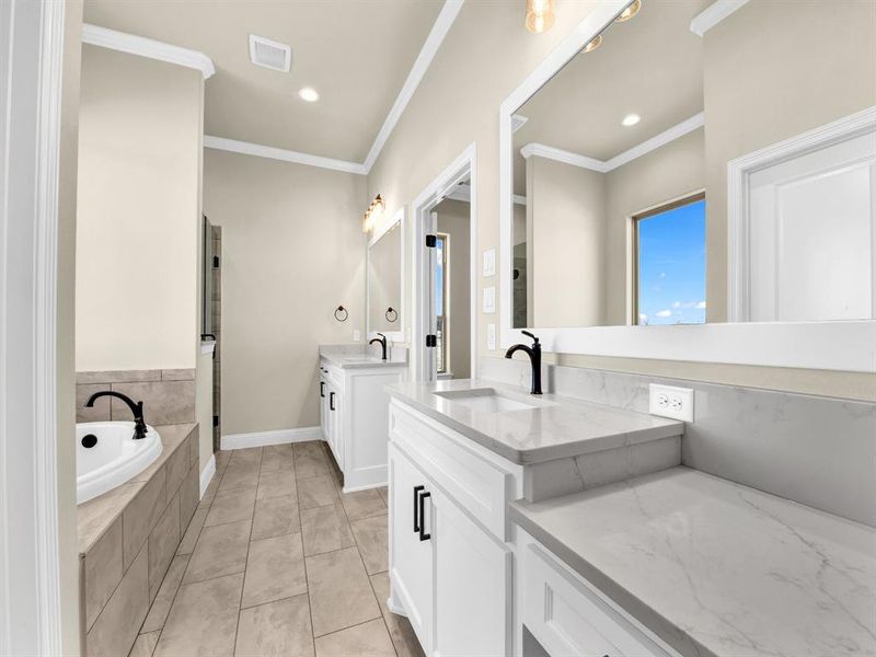 Bathroom featuring ornamental molding, a relaxing tiled tub, tile patterned floors, and vanity