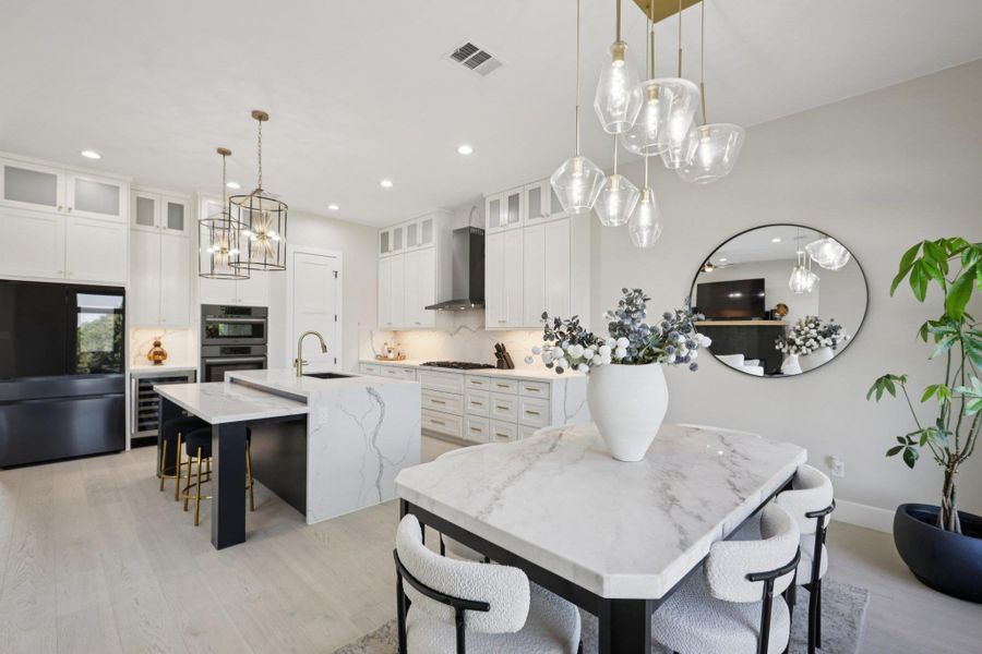 Dining area with hanging lights, light wood-type flooring, and wine cooler