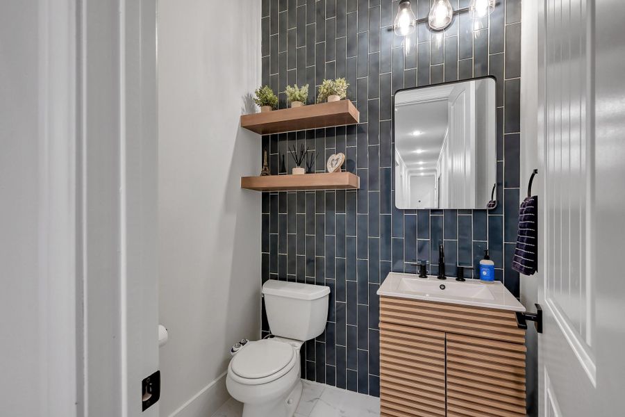Discover a modern kitchen with sleek cabinetry, a premium 48" Thor stainless steel gas range, and a wood vent hood. The elegant quartzite backsplash enhances the space.