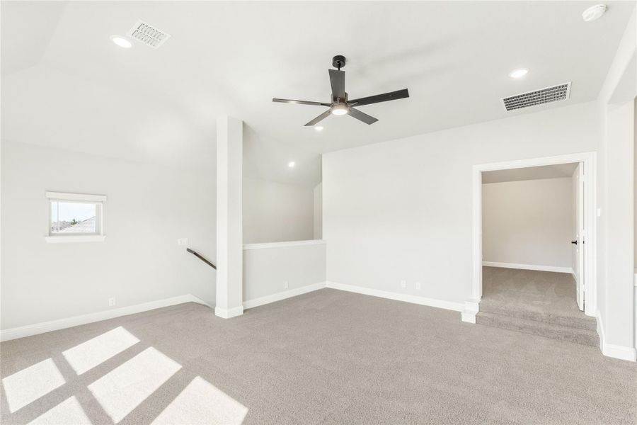 Open upstairs bonus room with carpet, ceiling fan, and doorway to walk-in closet Open upstairs bonus room with carpet, ceiling fan, and doorway to walk-in closet