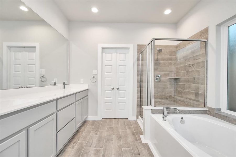 The primary en-suite has a soaking tub to give you that spa experience. The large privacy window allow lots of nature light in the space. Sample photo of completed home with similar floor plan. As-built interior colors and selections may vary.