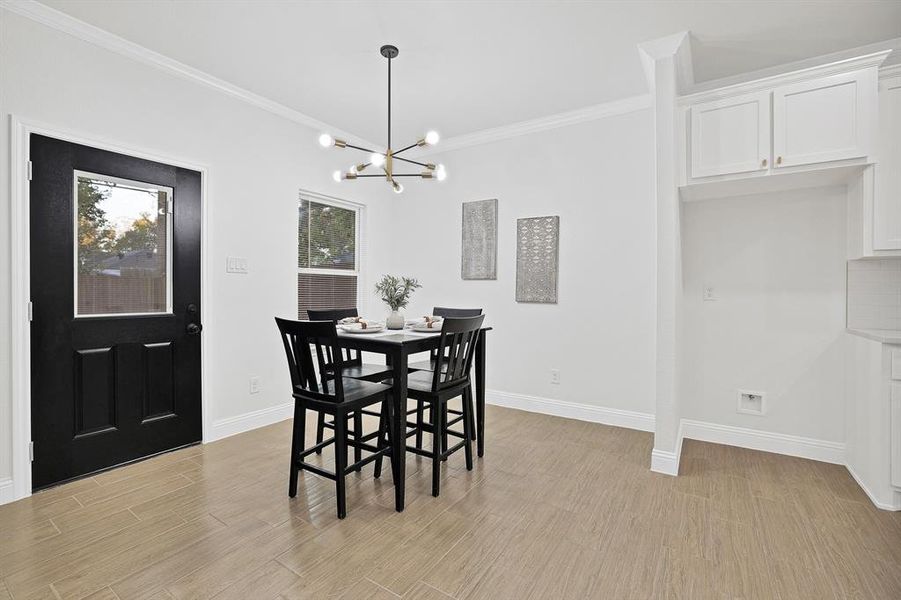 Dining area with an inviting chandelier, crown molding, wood-style flooring