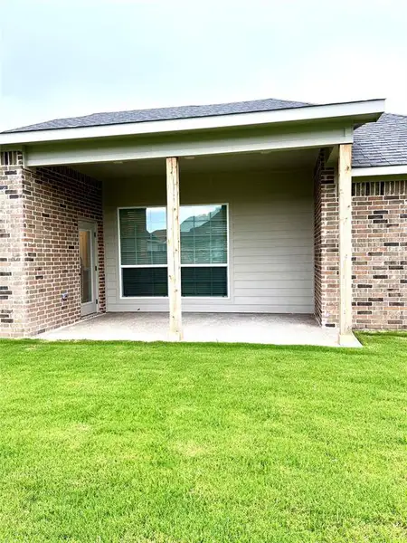 Back of property featuring a patio, a yard, and brick siding Back of property featuring a patio, a yard, and brick siding