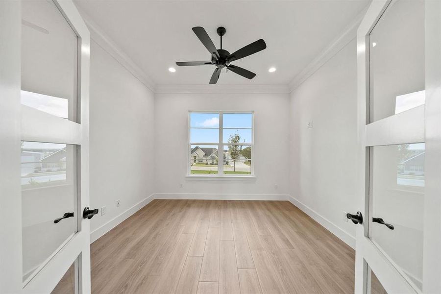 Spare room with light wood-style flooring, french doors, crown molding, recessed lighting, and a ceiling fan Spare room with light wood-style flooring, french doors, crown molding, recessed lighting, and a ceiling fan