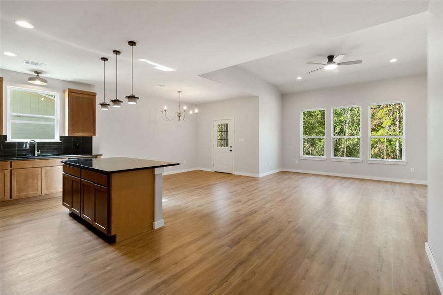 Kitchen with recessed lighting, open floor plan, dark countertops, and ceiling fan