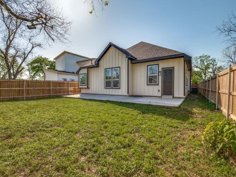 Rear view of house featuring a patio, roof with shingles, board and batten siding, a fenced backyard, and a yard Rear view of house featuring a patio, roof with shingles, board and batten siding, a fenced backyard, and a yard
