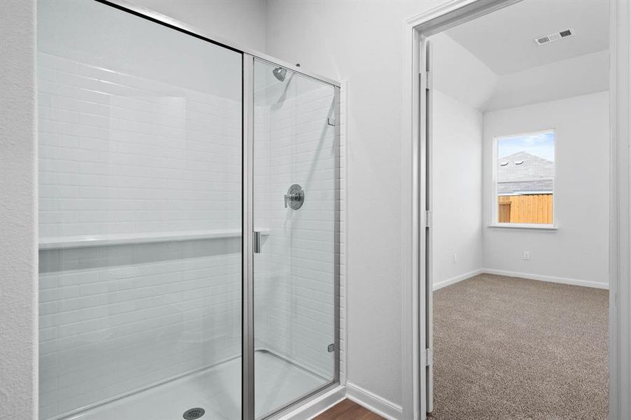 Full bath with a shower stall and dark carpet Full bath with a shower stall and dark carpet