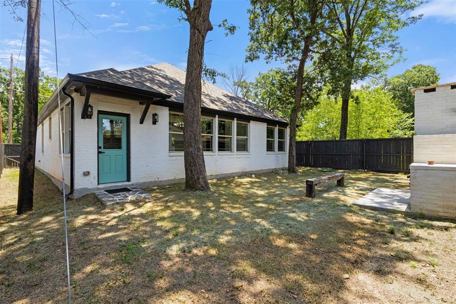 Back of house featuring a shingled roof and brick siding Back of house featuring a shingled roof and brick siding
