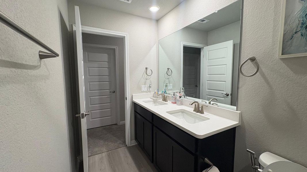 Dual vanity with bright lighting elevates this functional and stylish primary bathroom.