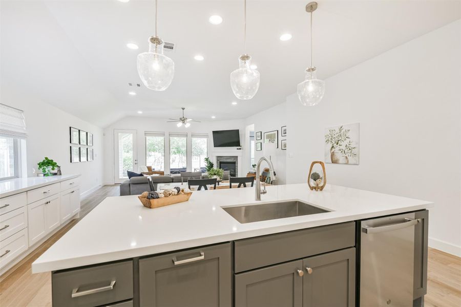 Trash drawer, quartz counters, and pendant lighting enhance the island along with views of the private backyard. Trash drawer, quartz counters, and pendant lighting enhance the island along with views of the private backyard.