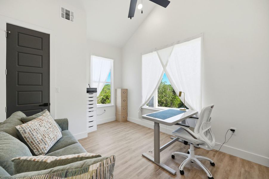A vaulted ceiling and wood-finish flooring define this airy home workspace.