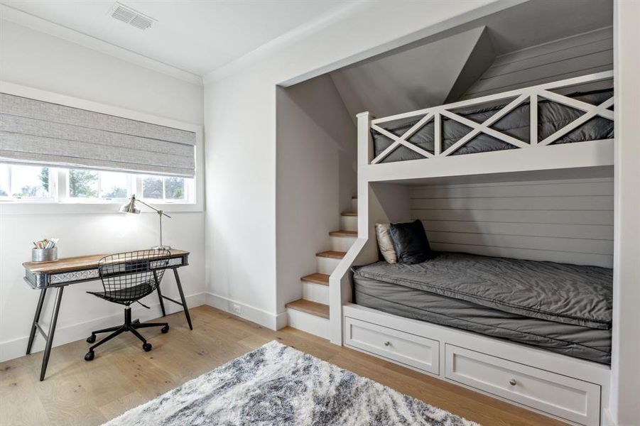 Bedroom with light wood finished floors, baseboards, visible vents, and crown molding Bedroom with light wood finished floors, baseboards, visible vents, and crown molding