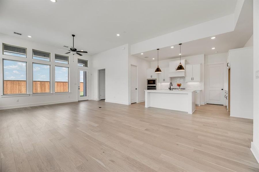 Unfurnished living room featuring recessed lighting, light wood-style flooring, and ceiling fan Unfurnished living room featuring recessed lighting, light wood-style flooring, and ceiling fan