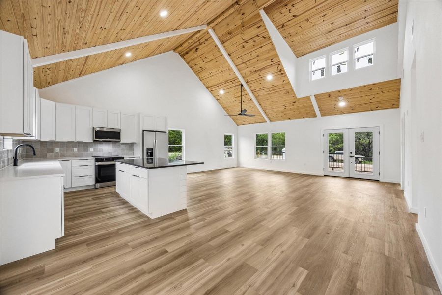 A striking vaulted wood-paneled ceiling highlights this open-concept kitchen and living area. A striking vaulted wood-paneled ceiling highlights this open-concept kitchen and living area.