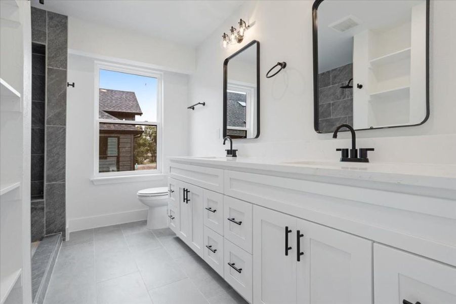 Bathroom with tile patterned flooring, vanity, and toilet