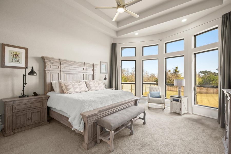 Bedroom featuring a high ceiling, light colored carpet, ceiling fan, and recessed lighting Bedroom featuring a high ceiling, light colored carpet, ceiling fan, and recessed lighting