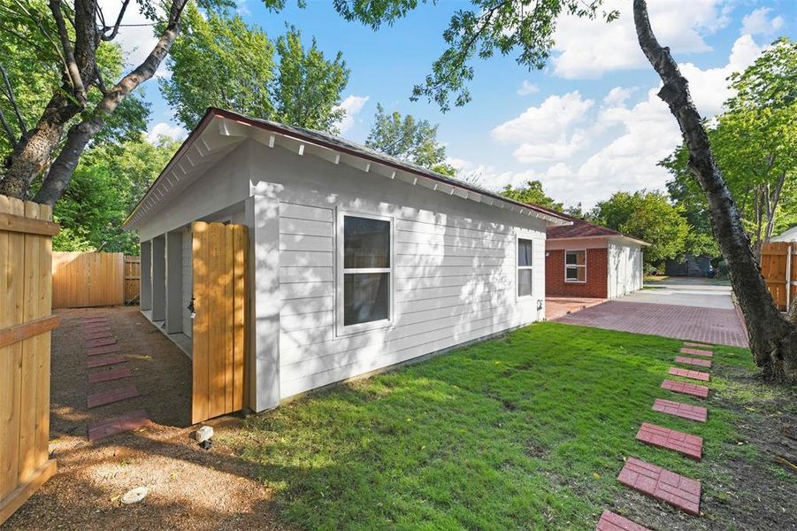 View of side of home with a yard and a patio