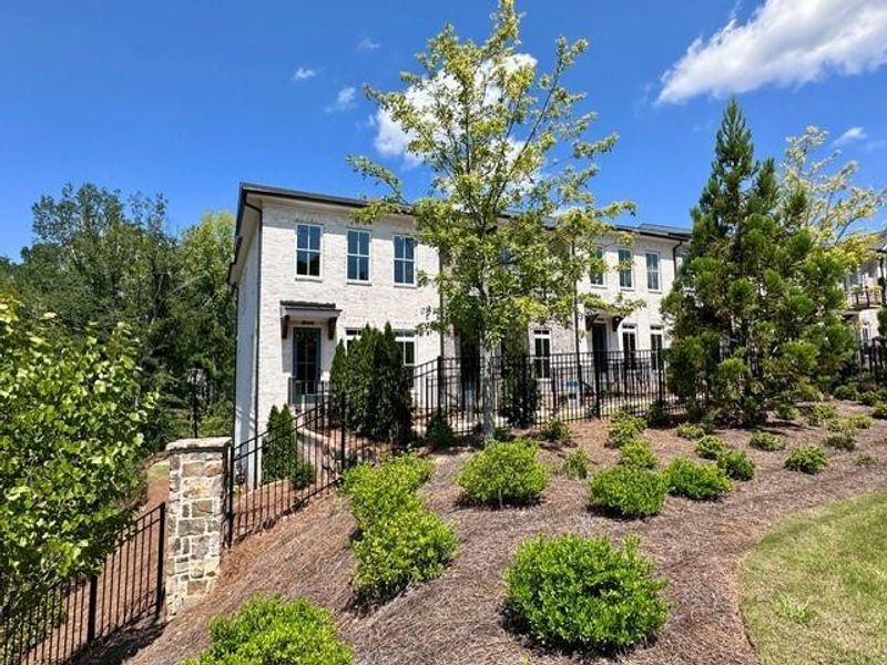 Front exterior of a new home in Ward's Crossing Townhomes, Johns Creek, GA, highlighting curb appeal (Image 18). Front exterior of a new home in Ward's Crossing Townhomes, Johns Creek, GA, highlighting curb appeal (Image 18).