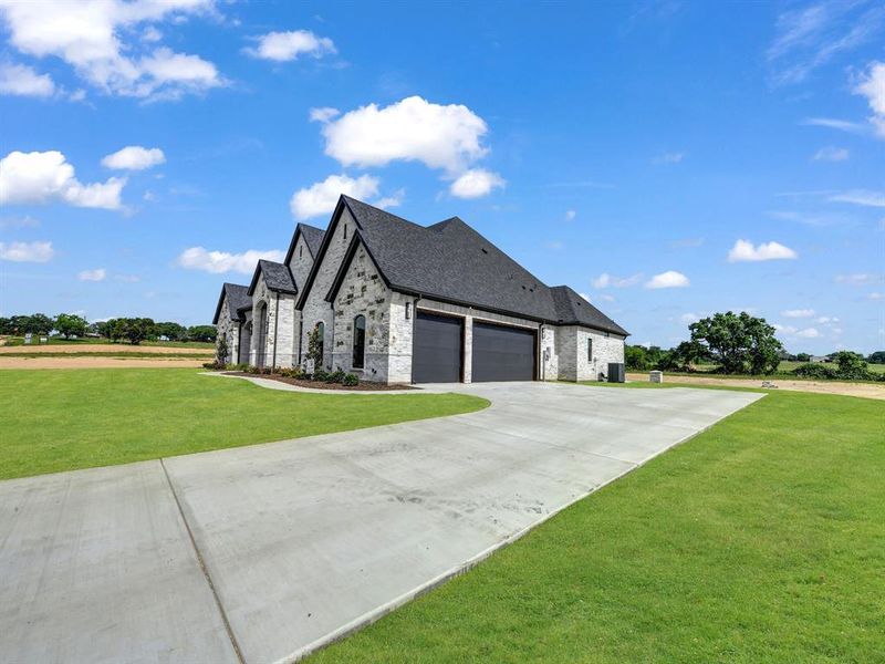 View of side of home featuring an attached garage, a lawn, brick siding, concrete driveway, and a shingled roof View of side of home featuring an attached garage, a lawn, brick siding, concrete driveway, and a shingled roof