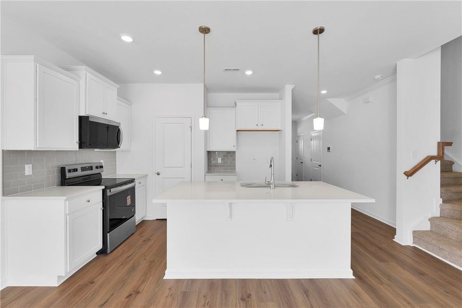 This kitchen features a central island, modern app This kitchen features a central island, modern app