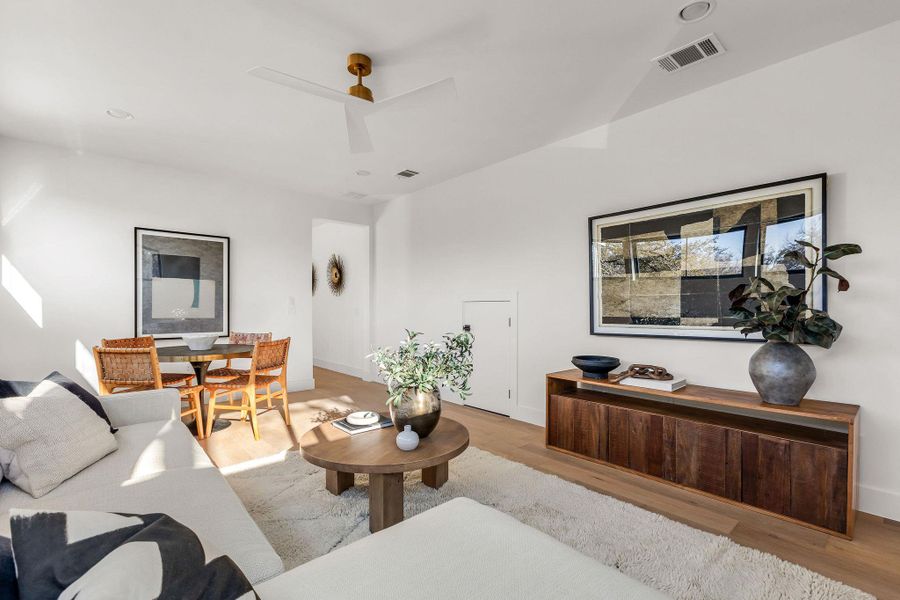 Living area with wood finished floors and ceiling fan