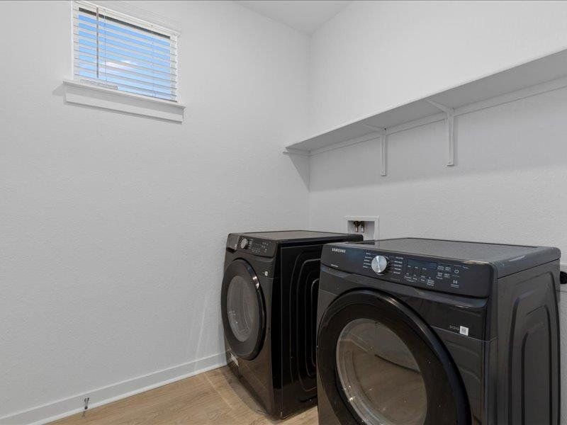Laundry room featuring light wood-style floors and independent washer and dryer