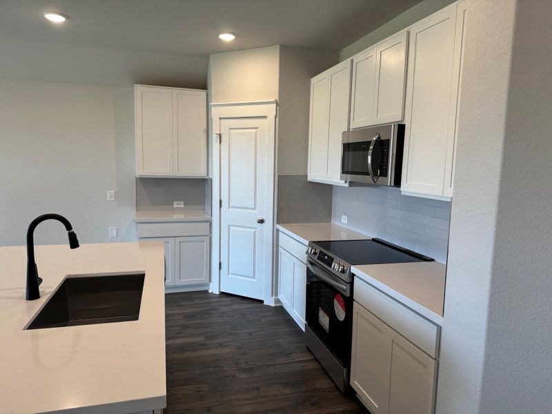 Kitchen with stainless steel appliances, white cabinets, recessed lighting, light countertops, and tasteful backsplash Kitchen with stainless steel appliances, white cabinets, recessed lighting, light countertops, and tasteful backsplash