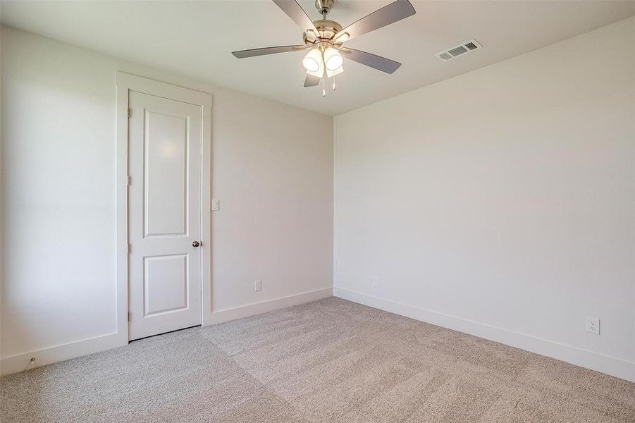 Carpeted empty room with ceiling fan