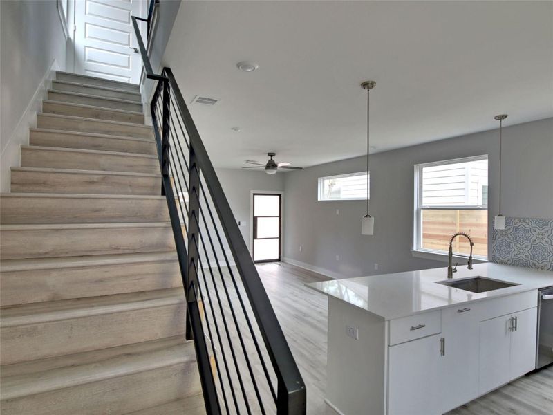 Stairway featuring wood finished floors and a ceiling fan