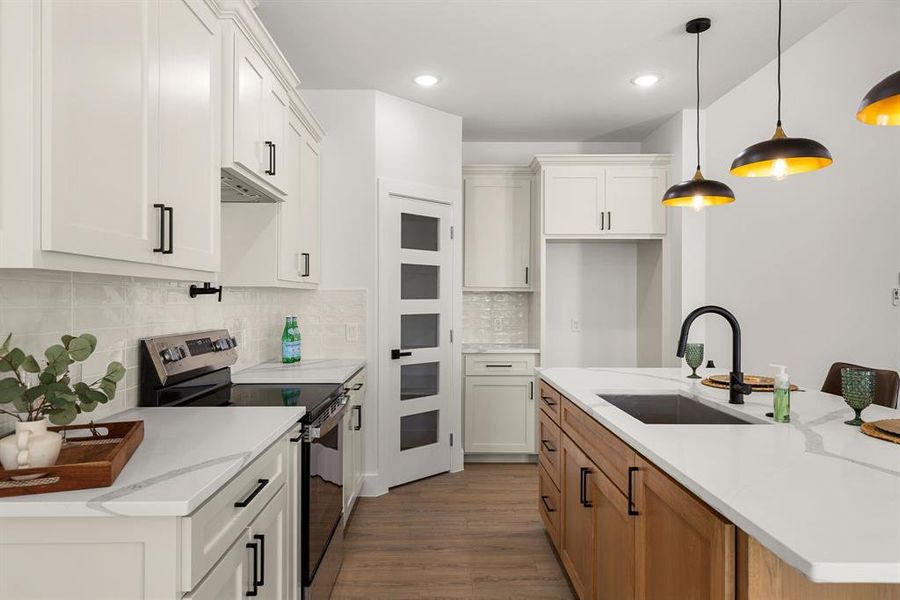 Kitchen featuring a sink, white cabinetry, electric stove, dark wood-style floors, and an island with sink