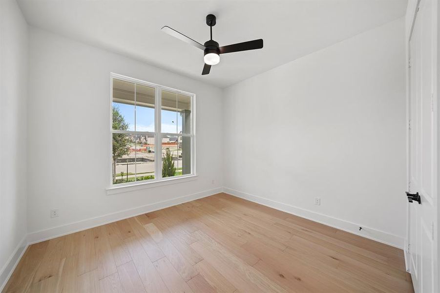 Empty room with light wood-style floors and a ceiling fan Empty room with light wood-style floors and a ceiling fan