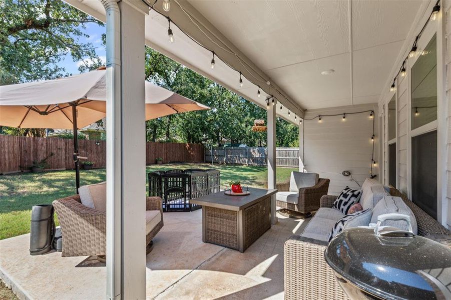 Relax and entertain on the covered back patio featuring string lights, sitting area, and extended outdoor living space. Relax and entertain on the covered back patio featuring string lights, sitting area, and extended outdoor living space.