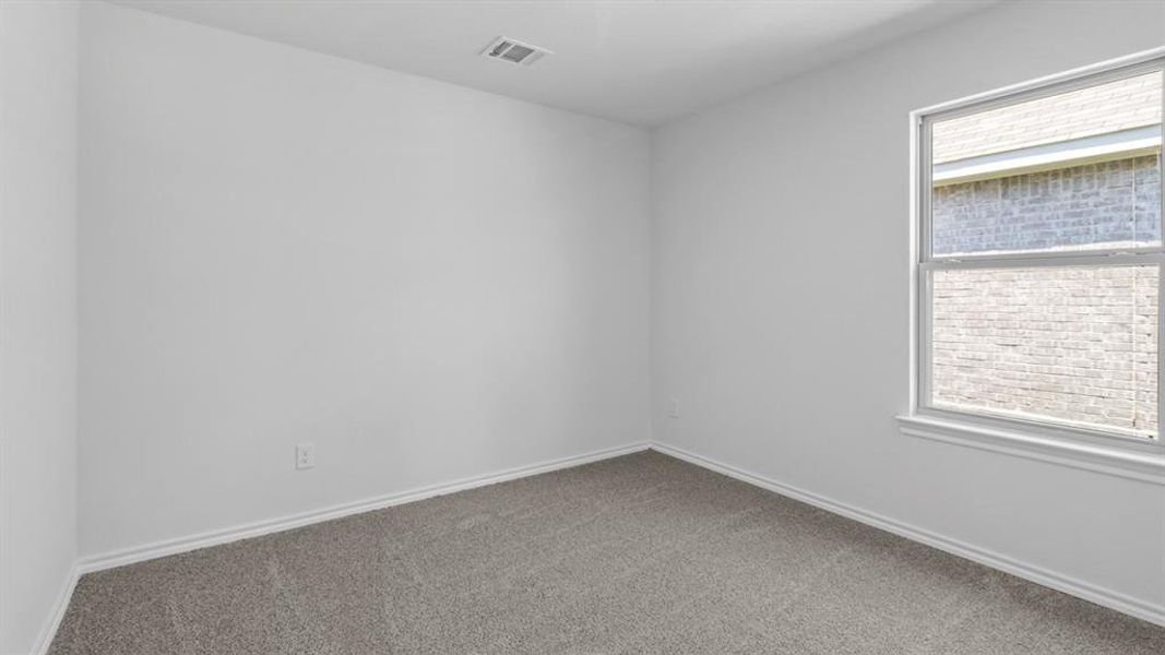 Interior room featuring plush gray carpet, white walls, white baseboards, and a single window with a white frame