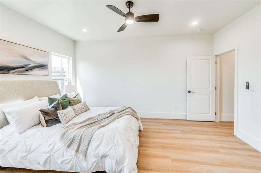 Bedroom with light hardwood / wood-style floors and ceiling fan