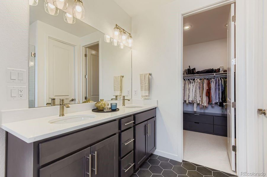 A spa-inspired primary bath showcases upgraded cabinetry, elegant countertops, and custom tile, paired with a generous walk-in closet for everyday luxury.