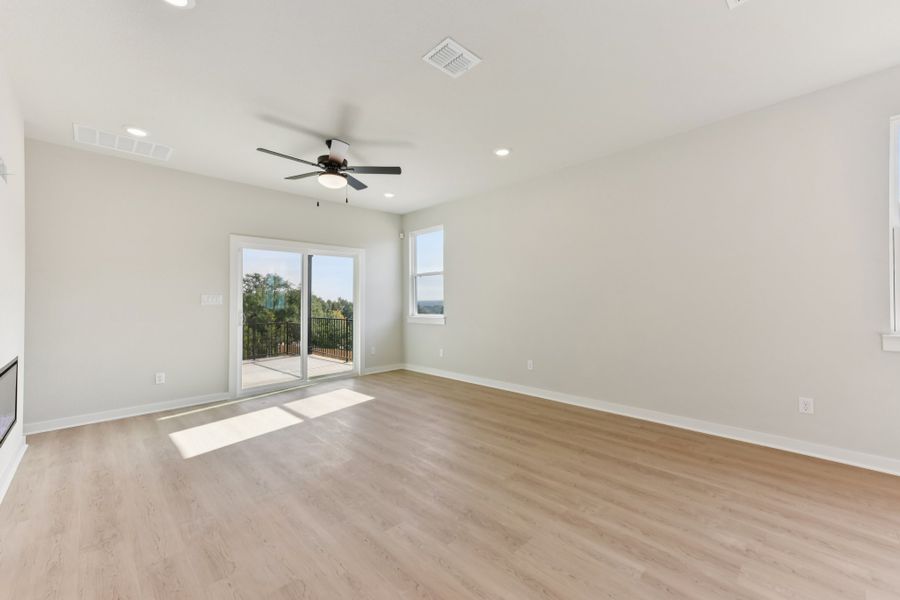 A room with a wood floor and a wood floor with a fan. A room with a wood floor and a wood floor with a fan.