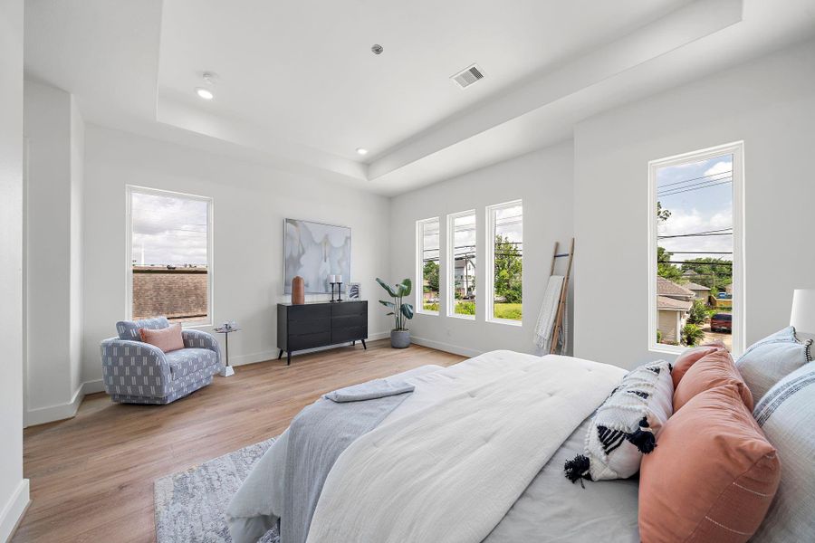 Bright and spacious primary bedroom with large windows, modern decor, and LVP flooring. Bright and spacious primary bedroom with large windows, modern decor, and LVP flooring.