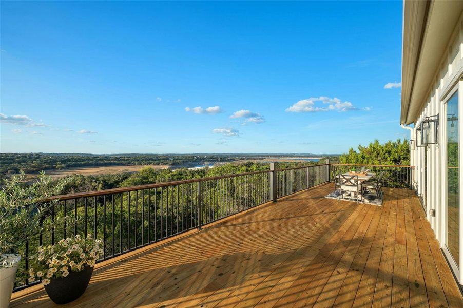 Four panel, dual opening glass sliders open both the living area and the primary bedroom onto this spectacular upper level entertainer's balcony where you can enjoy views of Hurst Creek Arm of Lake Travis.